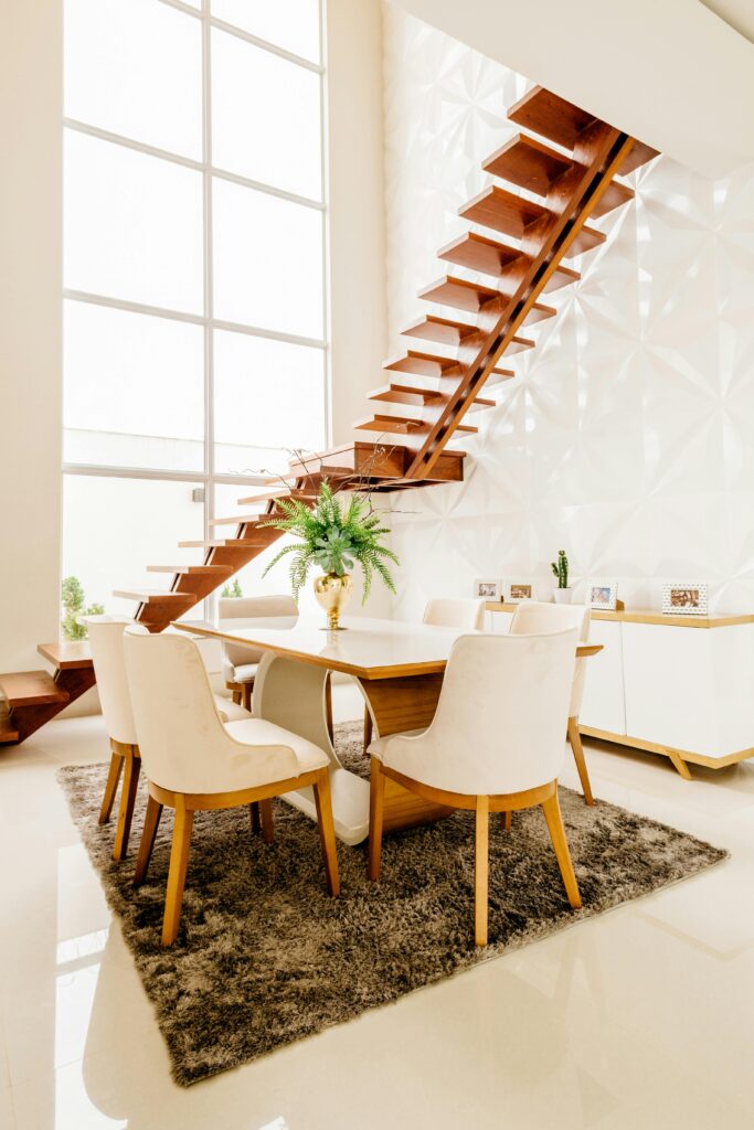 a dining table with chairs in a room with a staircase