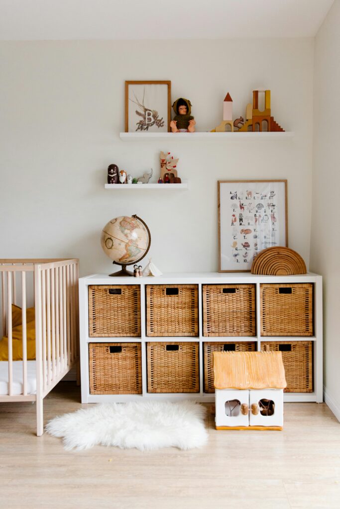 a white shelf with baskets and a globe on it